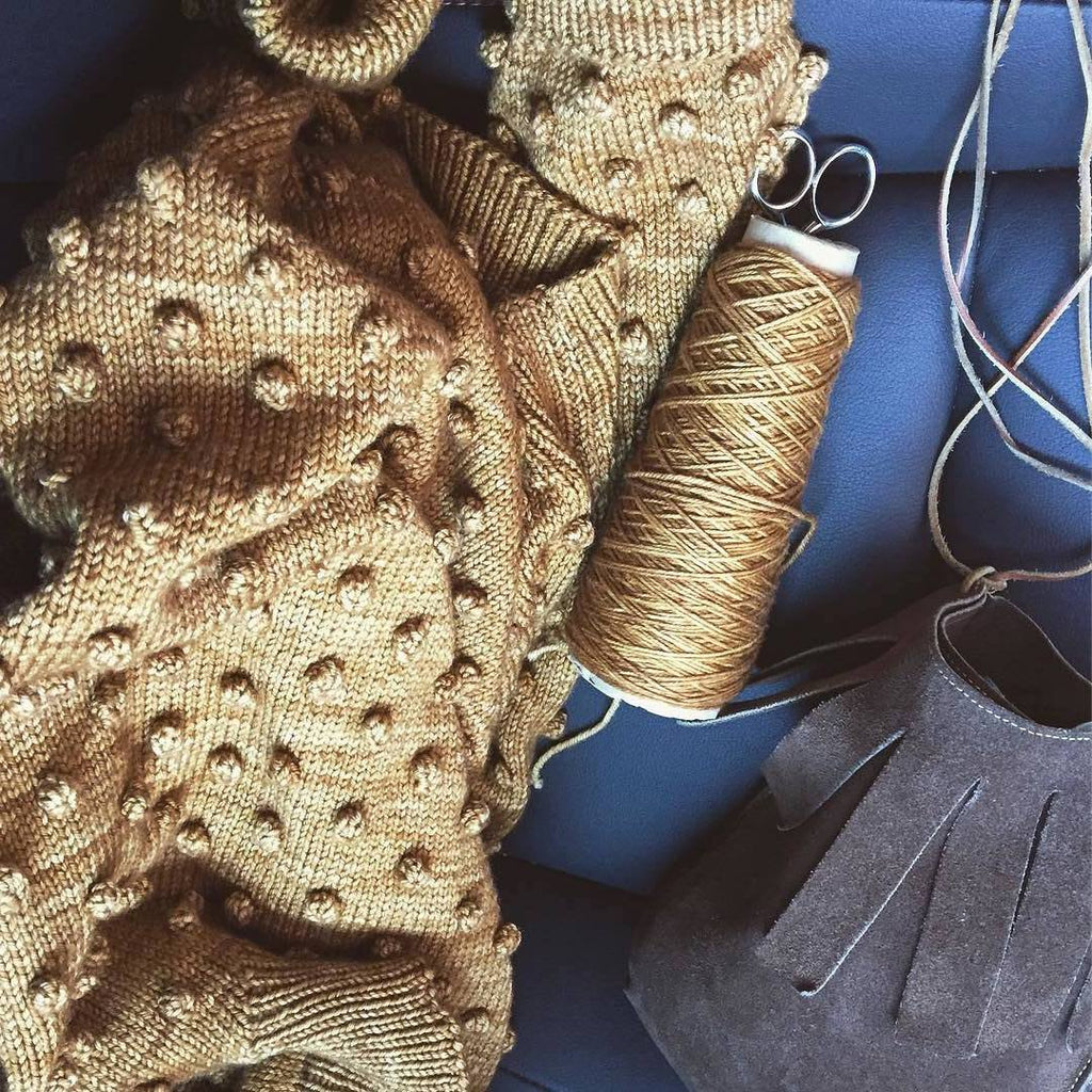 taylor and max children's boutique is a community that is knitted together in sustainability, culture, inclusivity and style. This is a photo of a rose gold hand knitted popcorn sweater that's handknitted by artisans in Peru. 